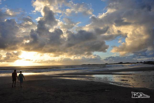 O Rodrigo e sua mãe caminham na praia enquanto o dia nasce em Punta del Diablo, no litoral do Uruguai